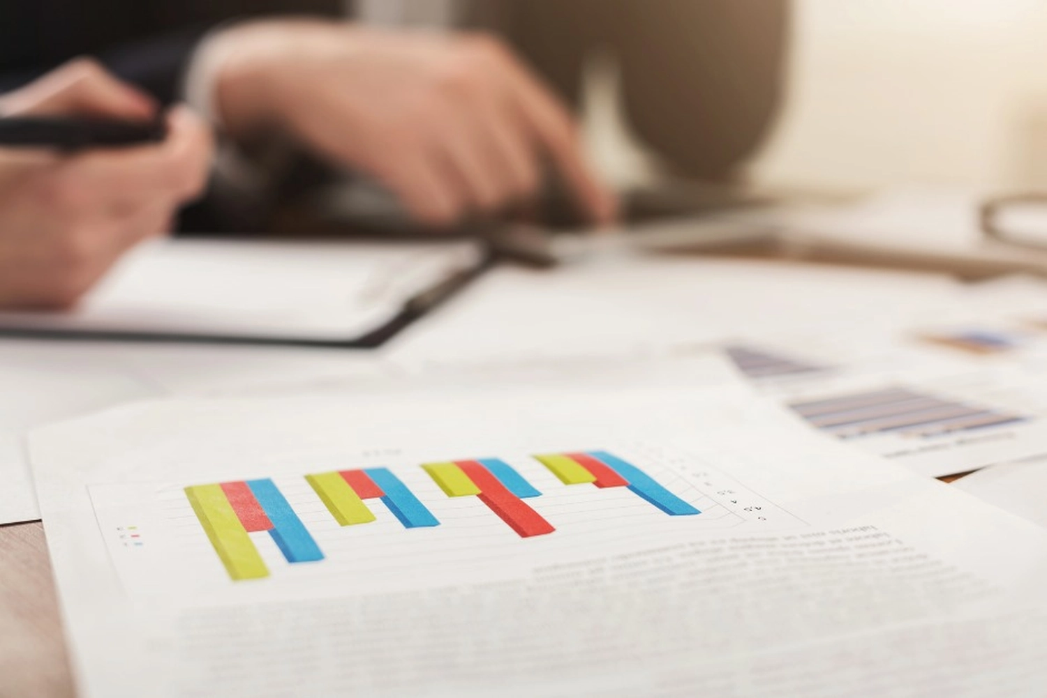 Choy Consulting UG – Finanzberater – Das Bild zeigt ein Geschäftstreffen mit Fokus auf ein Dokument mit Finanzprognosen oder einem Bericht.